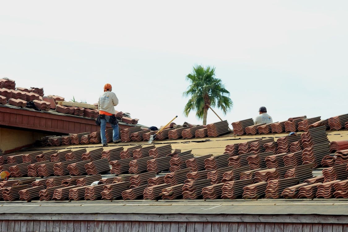 Workers on clay tile commercial roof